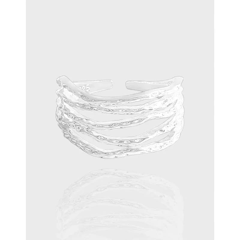 Polished sterling silver layered wave ring with five stacked, textured bands on a light background.