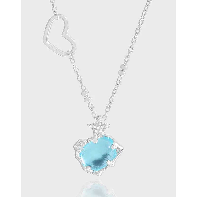 Silver necklace with an open heart charm and a blue irregular gemstone pendant.