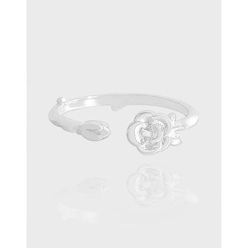 Polished sterling silver ring featuring a detailed rose blossom on the front of an open-ended band.