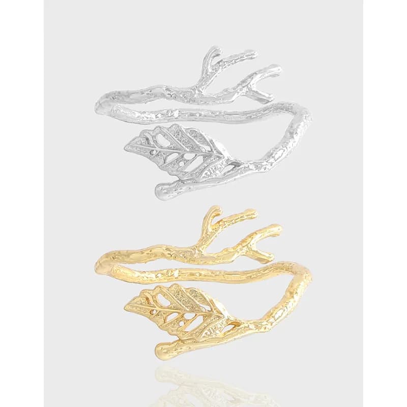 Polished sterling silver ring with a textured branch band and detailed leaf accent