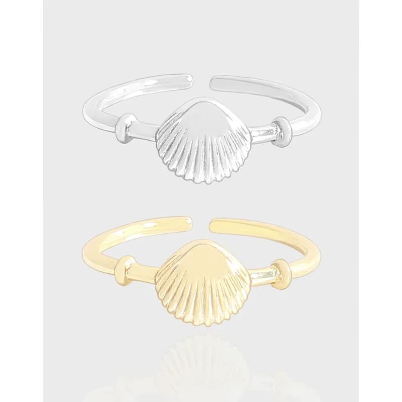 Polished scallop-shell centerpiece on an adjustable open ring in silver and gold-tone finishes.
