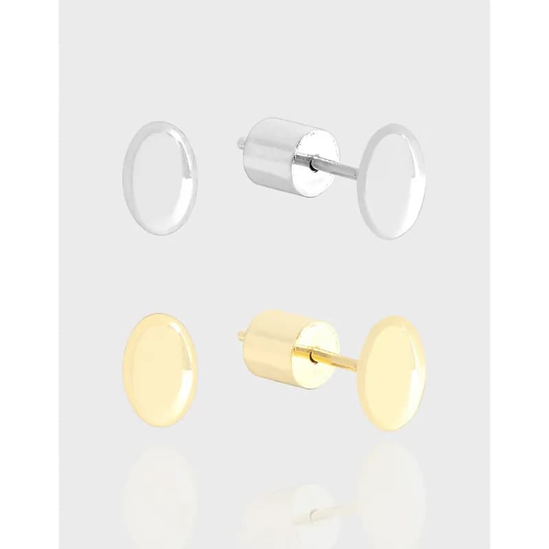 Polished circular disc stud earrings in silver with a gold-tone version visible in the background.