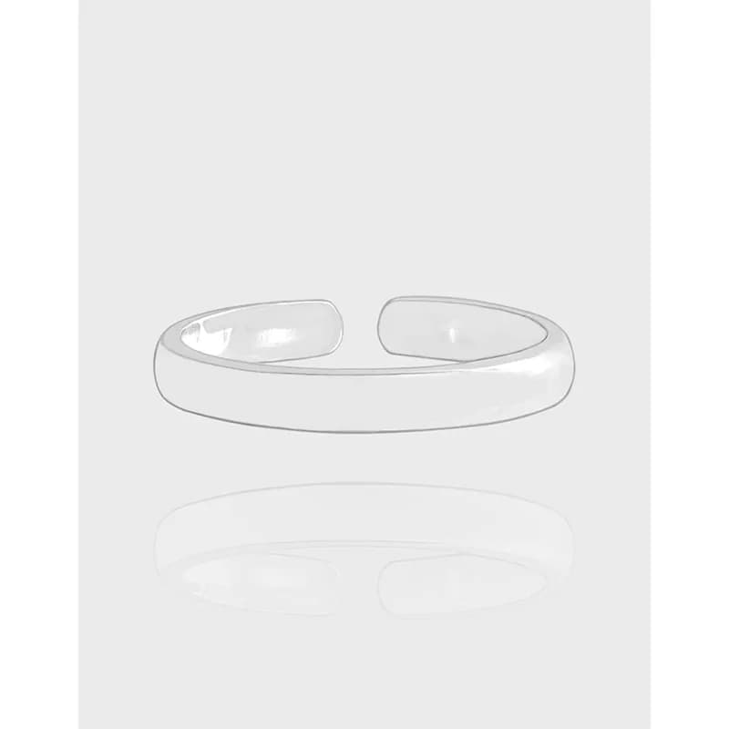 Polished sterling silver open cuff ring with a rounded, minimalist band on a neutral background.