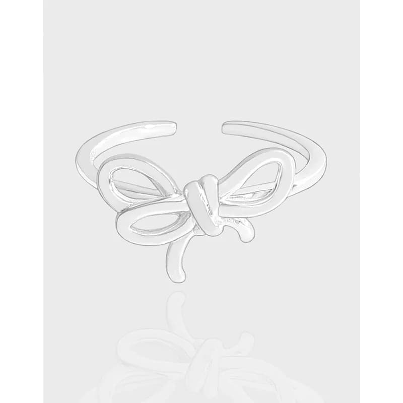 Polished sterling silver bow knot ring with open band and reflective surface.