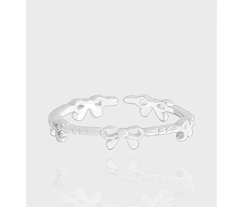 Polished sterling silver bow-link ring shown from the front with the bow shapes visible.