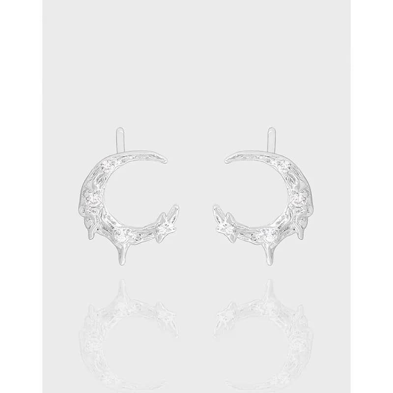 Polished sterling silver crescent moon hoop earrings with star accents on a light background.