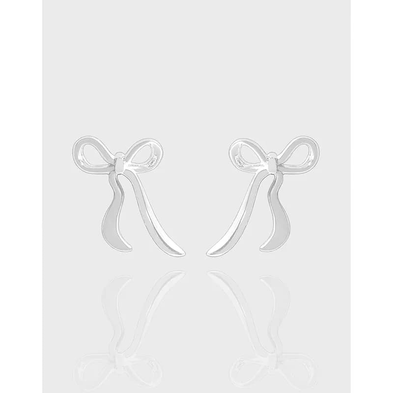 Polished sterling silver bow-shaped earrings on a light gray background