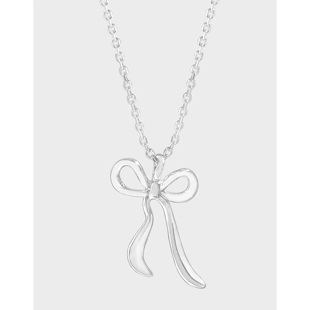 Polished sterling silver bow pendant hanging from a delicate chain.