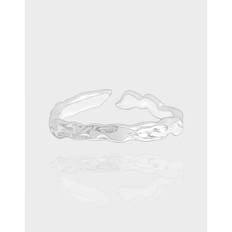 Polished sterling silver ring with an irregular, wavy textured band on a light gray background.