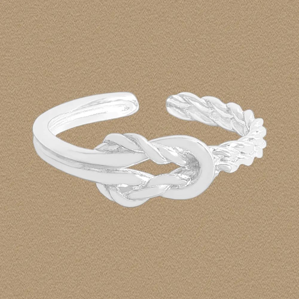 Polished sterling silver open ring with intertwined bands forming a knot on a warm beige background.
