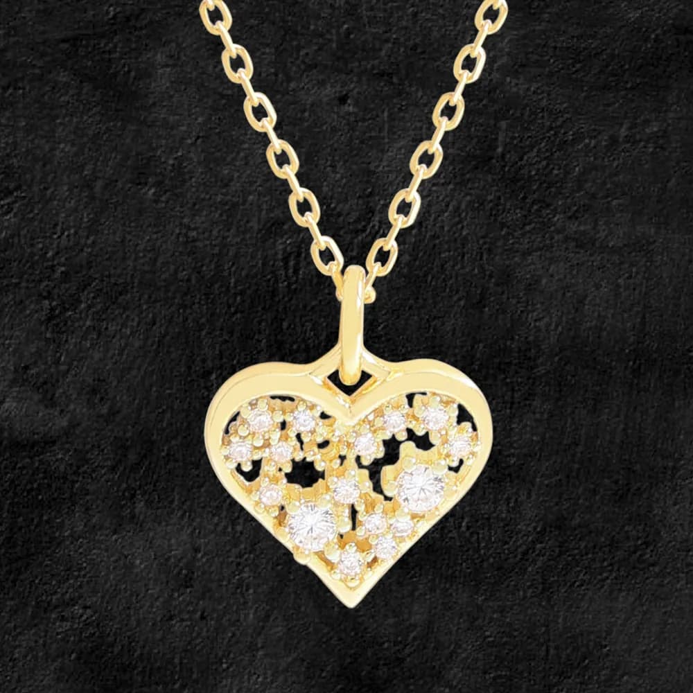 Polished heart-shaped pendant with crystal-studded open filigree on a chain against a black background.