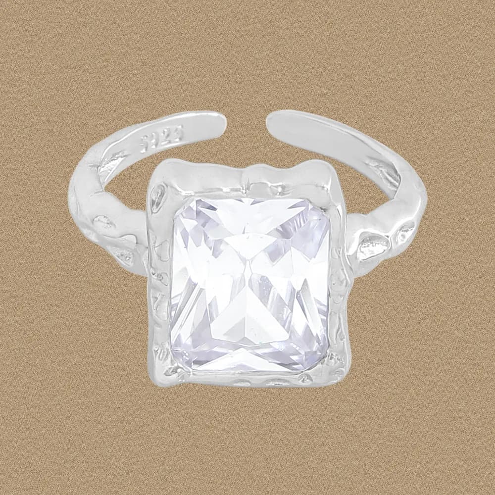 Sterling silver ring with a square cushion-cut stone set in a raised bezel and a textured band.