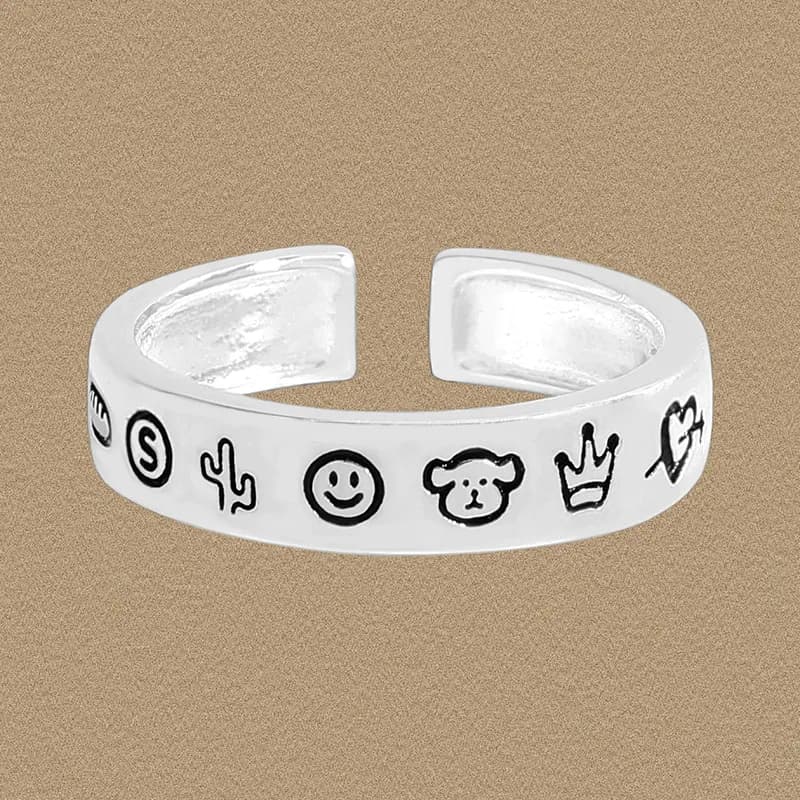 Polished sterling silver open-band ring with a sequence of black-outline doodle icons around the band.