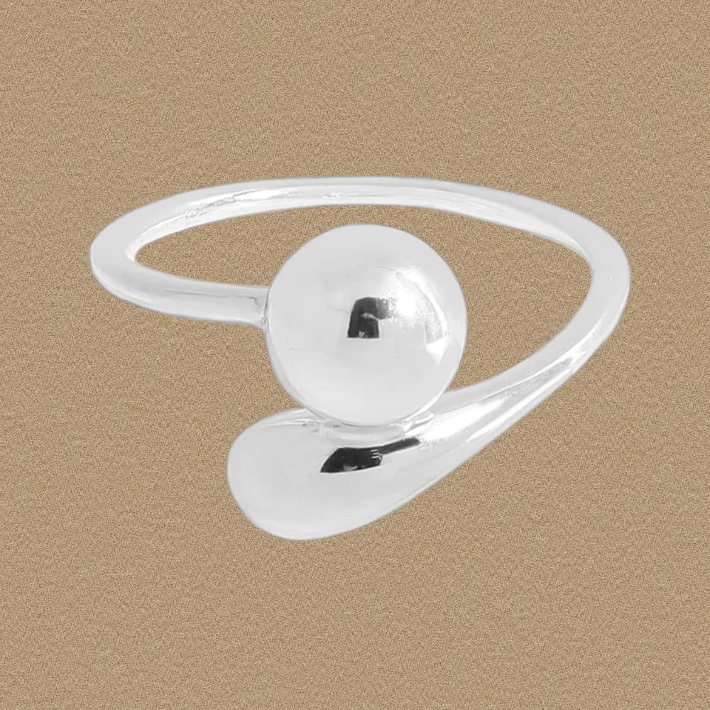 Polished sterling silver ring with a spherical bead and curved wrap design on a neutral background.