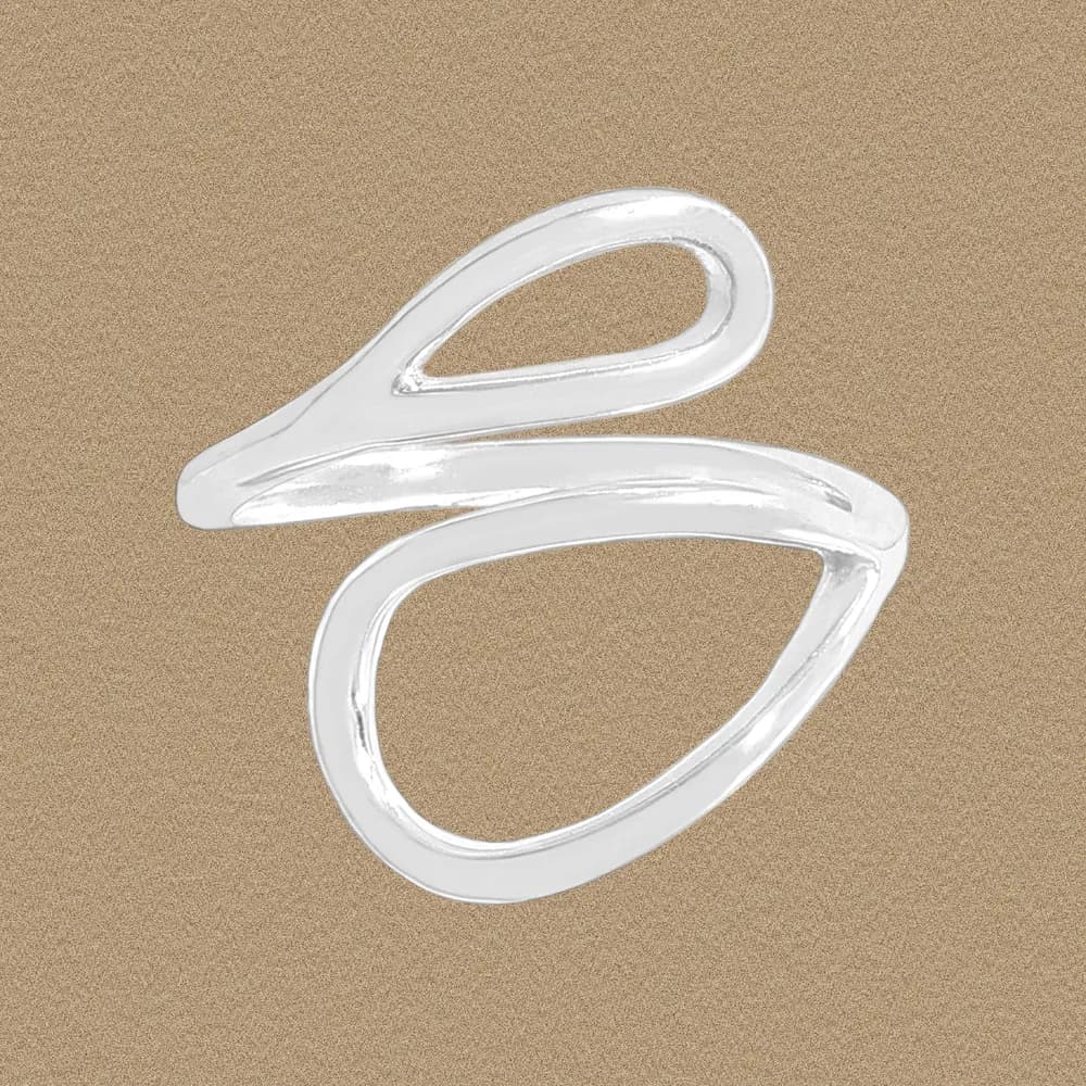 Polished abstract loop ring in sterling silver on a sandy background.