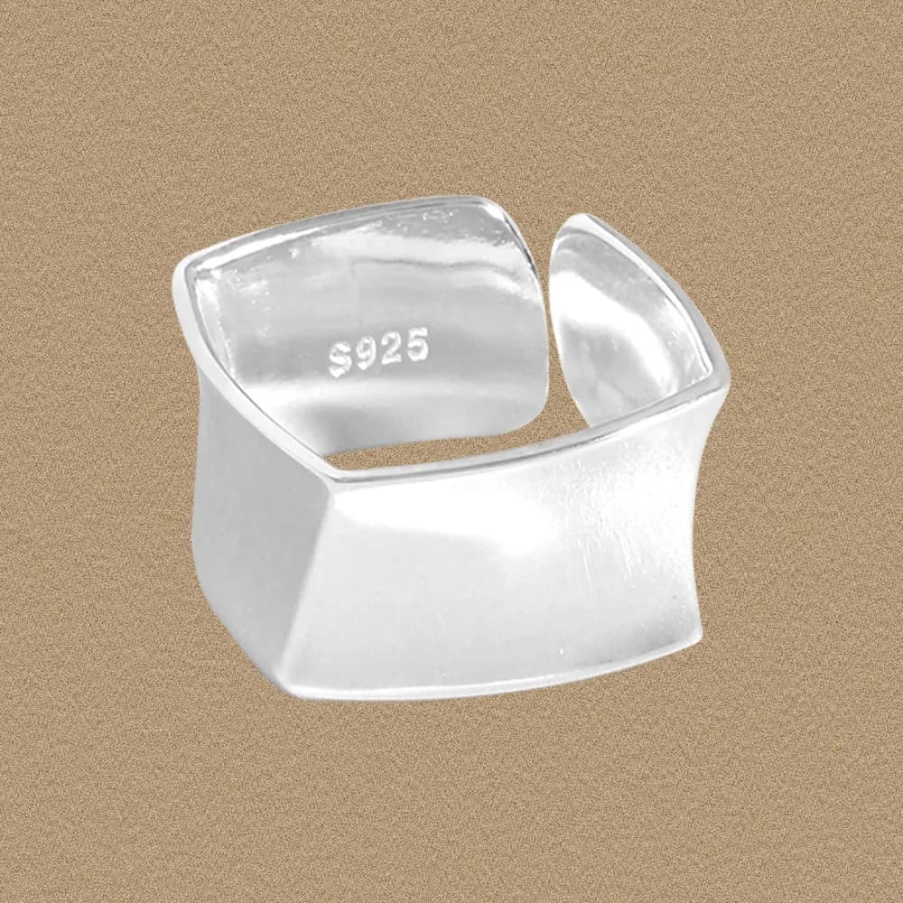 Polished sterling silver open cuff ring with a wide curved band and back gap.