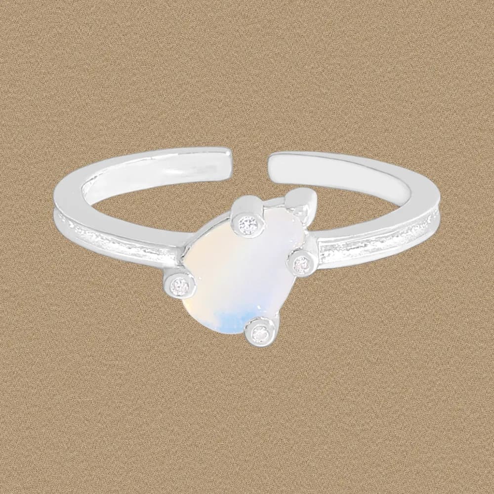 Sterling silver ring with an oval moonstone centerpiece and small accent stones on a textured band.
