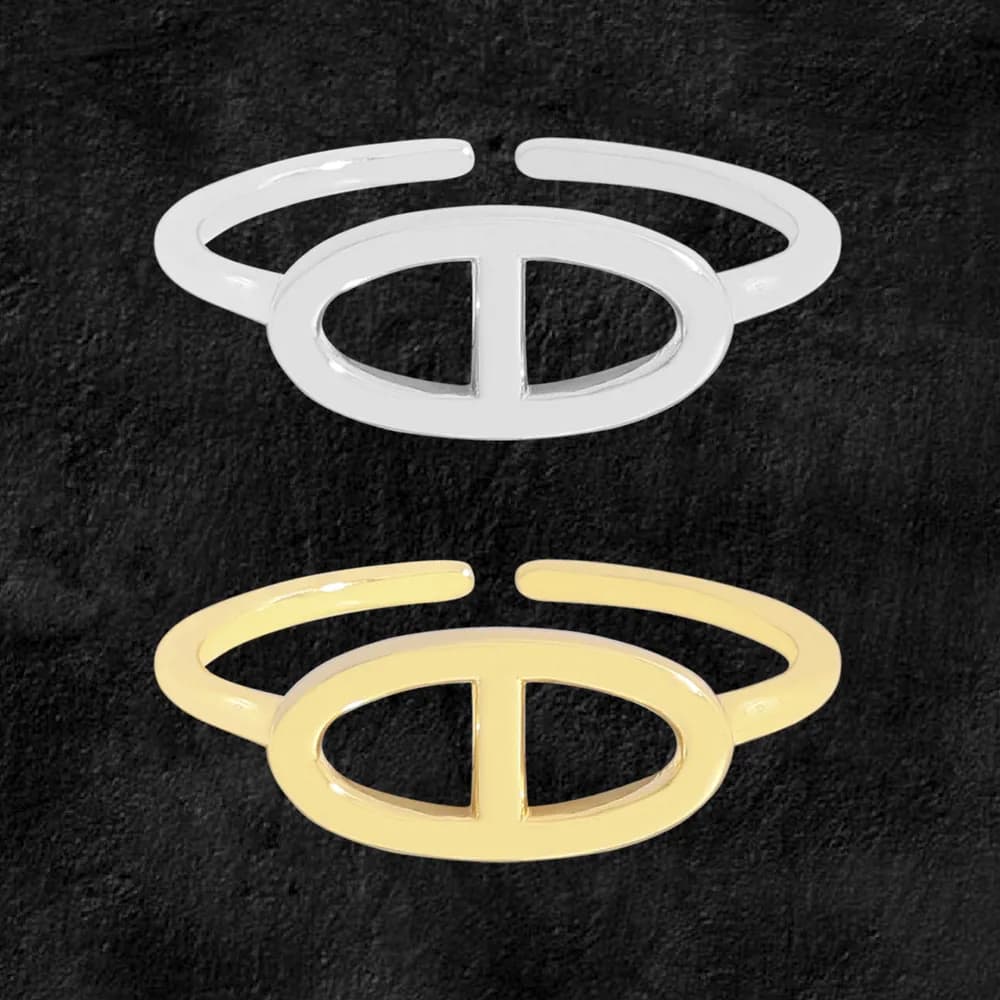 Two-tone open oval ring with a central divider in silver and gold tones on a dark background.