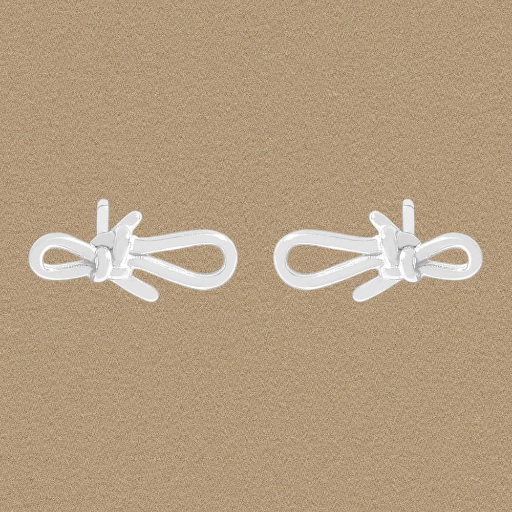 Two polished sterling silver bow knot stud earrings on a neutral background.