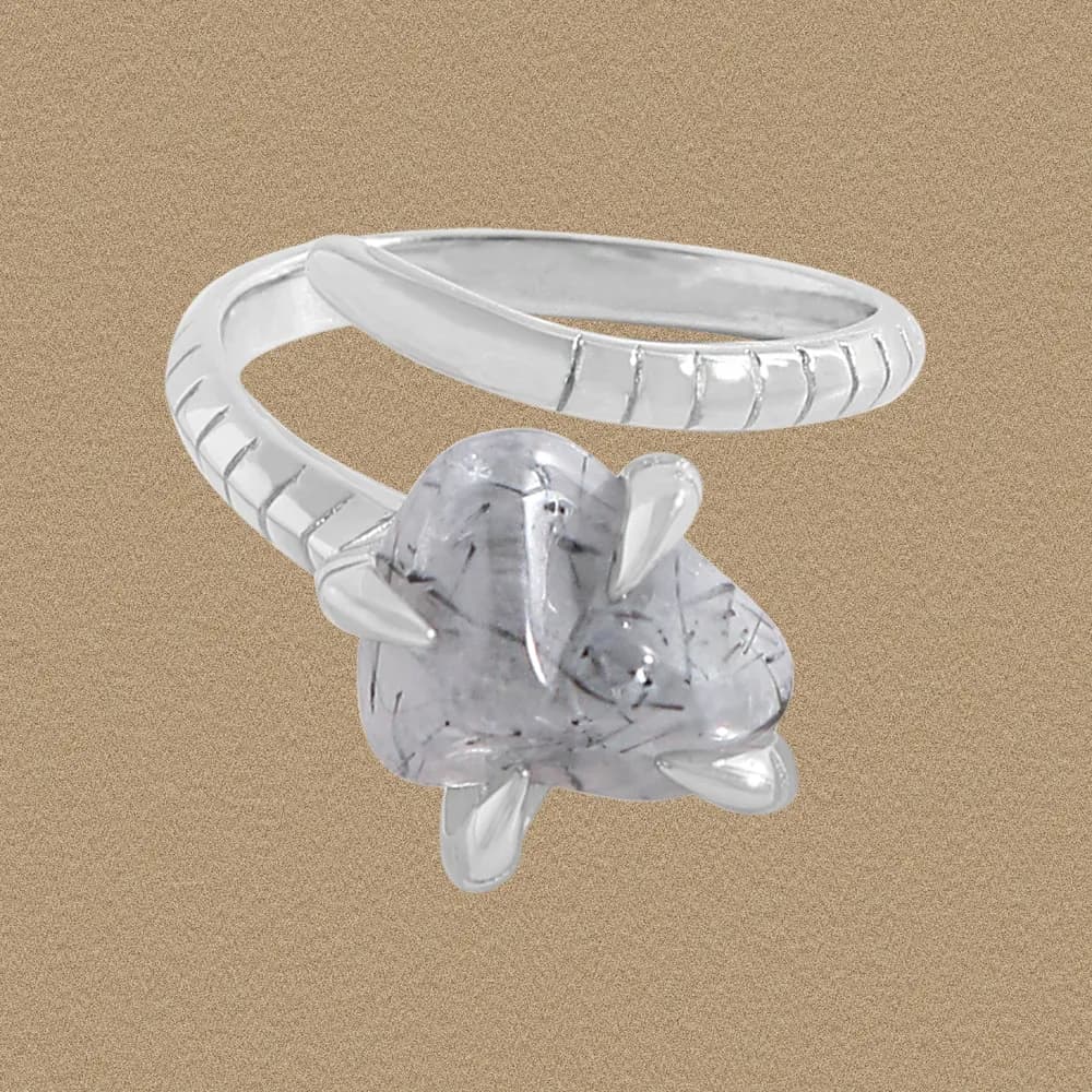 Sterling silver ring with a prong-set irregular dendritic quartz stone on a textured background.