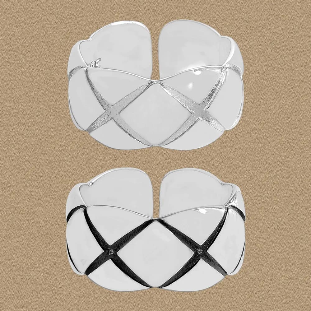 Wide sterling silver ring with a petal-inspired silhouette and crisscross bands across the top.