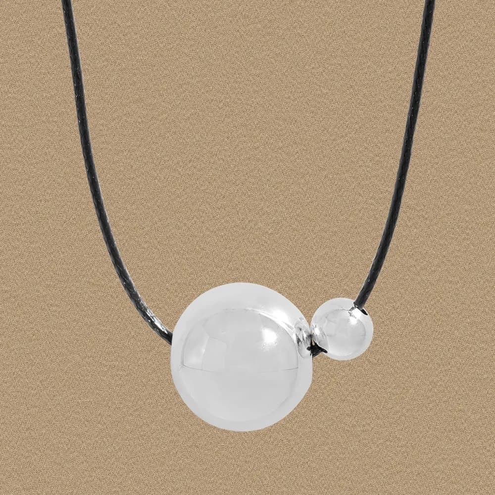 Polished sterling silver two-sphere pendant on a black cord necklace