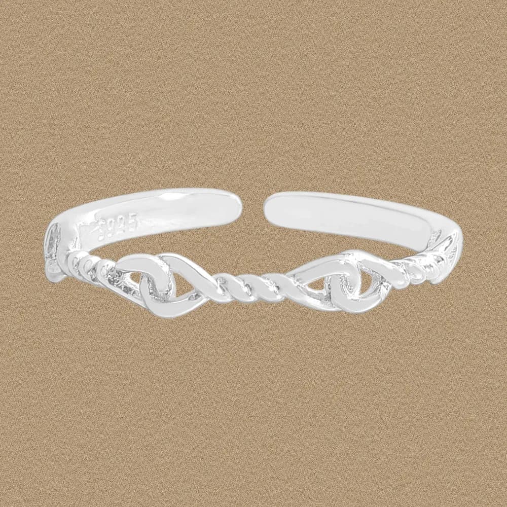 Polished sterling silver open cuff ring with a twisted rope knot design on a beige textured background.