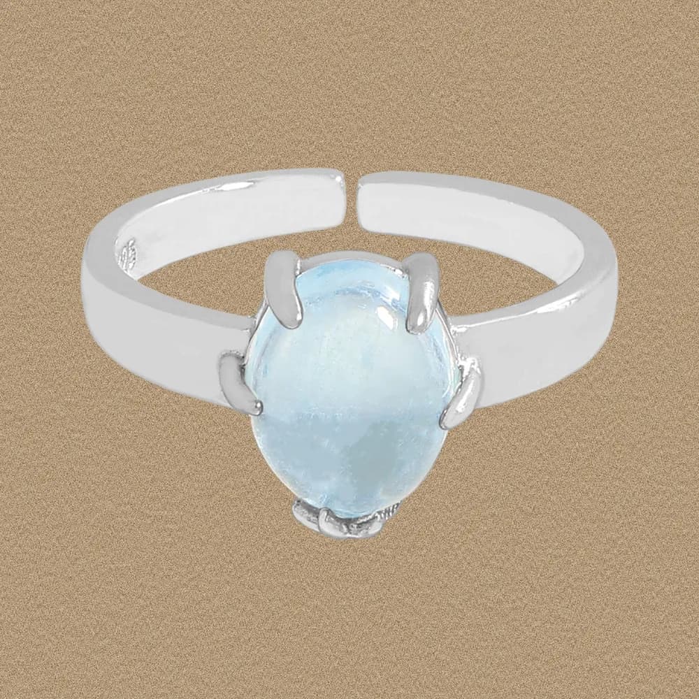 Polished sterling silver ring featuring an oval pale blue cabochon held by four prongs