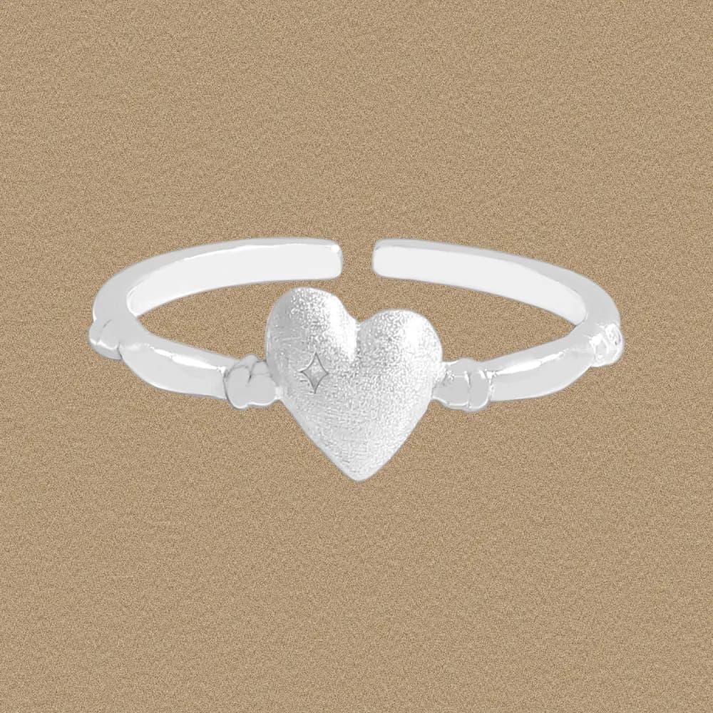 Polished sterling silver ring with a textured heart centerpiece on an open band.