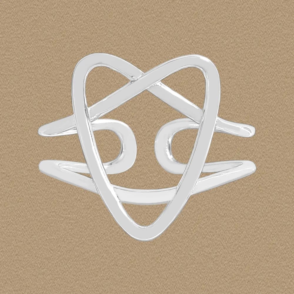 Polished sterling silver Crossed Loop Ring against a warm textured background.
