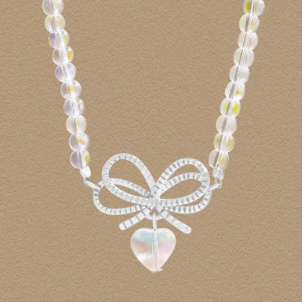 Sterling silver beaded necklace with a bow centerpiece and iridescent heart pendant