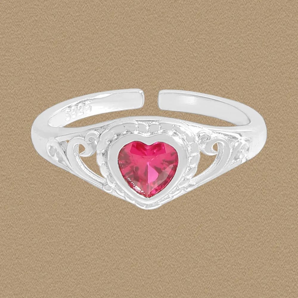 Sterling silver ring with a heart-shaped pink gemstone set in an ornate filigree heart centerpiece.