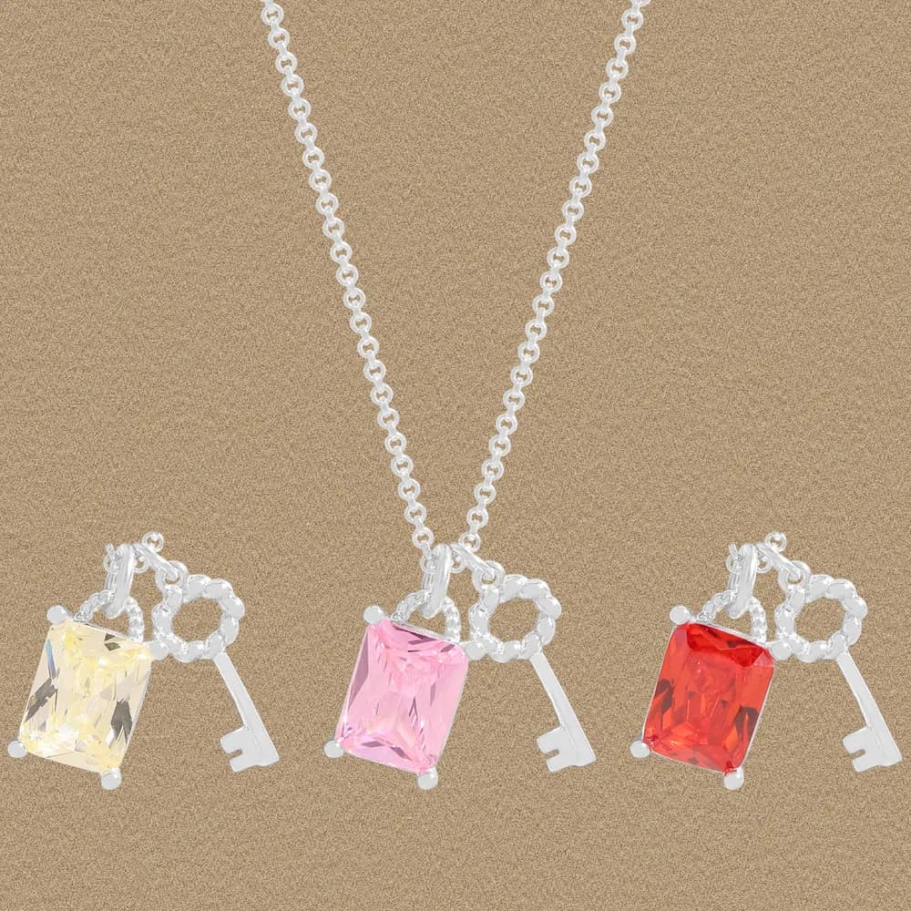 Three silver key pendant necklaces with rectangular colored gemstones on delicate chains.