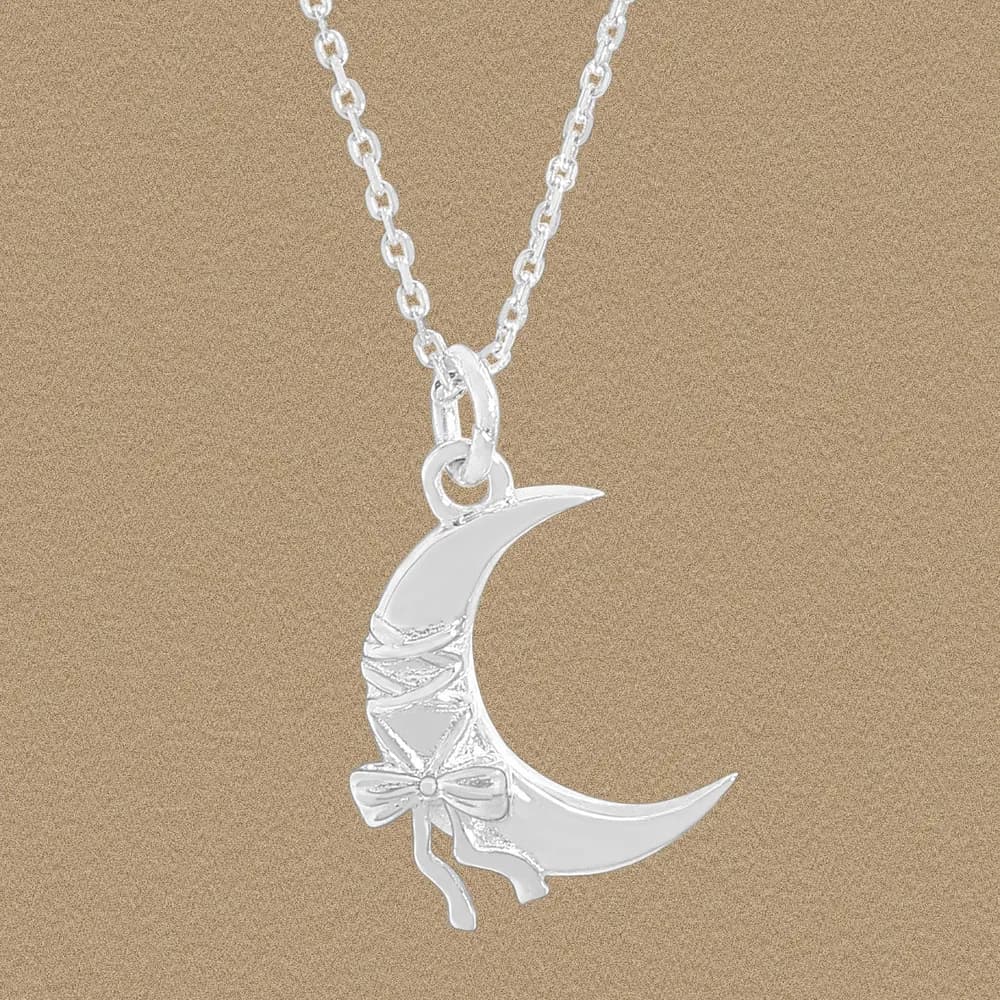 Polished sterling silver crescent moon pendant with a bow detail on a chain