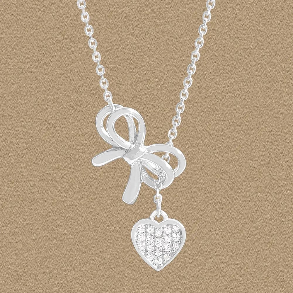 Polished sterling silver bow pendant with a pavé heart charm on a fine chain