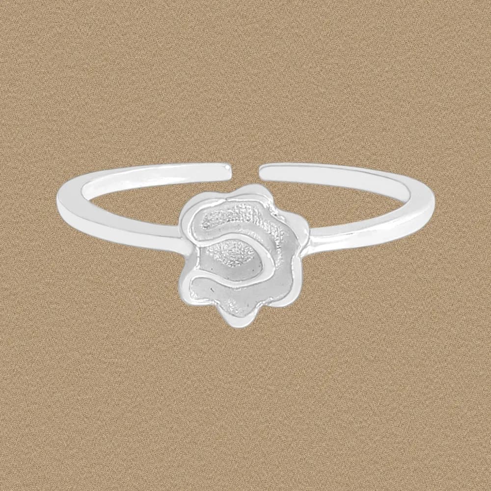 Close-up of a polished sterling silver ring with an open band and a layered rose-shaped centerpiece.