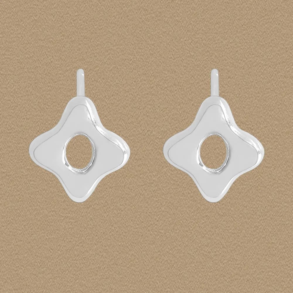 Polished sterling silver four-lobed clover-shaped studs with central hole on a neutral backdrop.