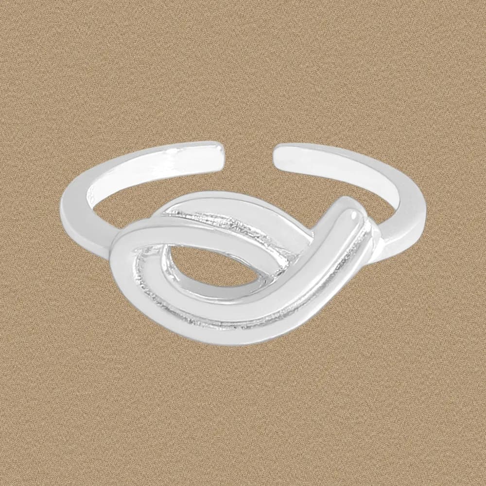 Polished sterling silver ring with an open knot design on a tan background.
