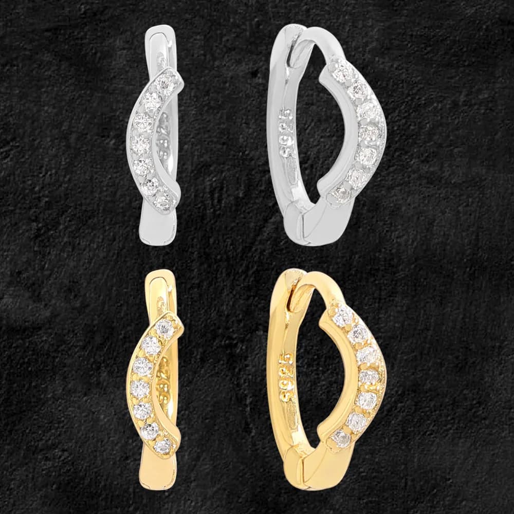 Close-up of pavé curved hoop earrings showing a row of stones along the outer edge on a dark background.