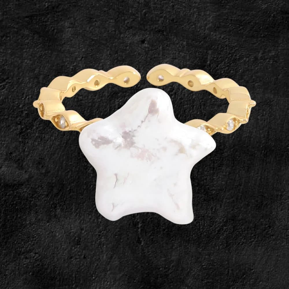 Polished sterling silver ring with a large star-shaped white centerpiece on a dark textured background.