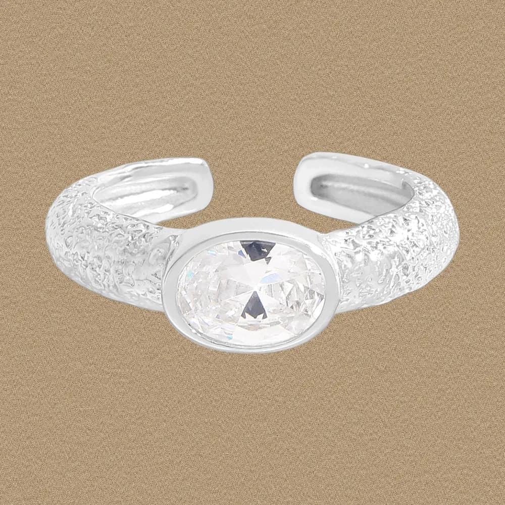 Sterling silver ring with a textured band and a bezel-set oval crystal centered on top.