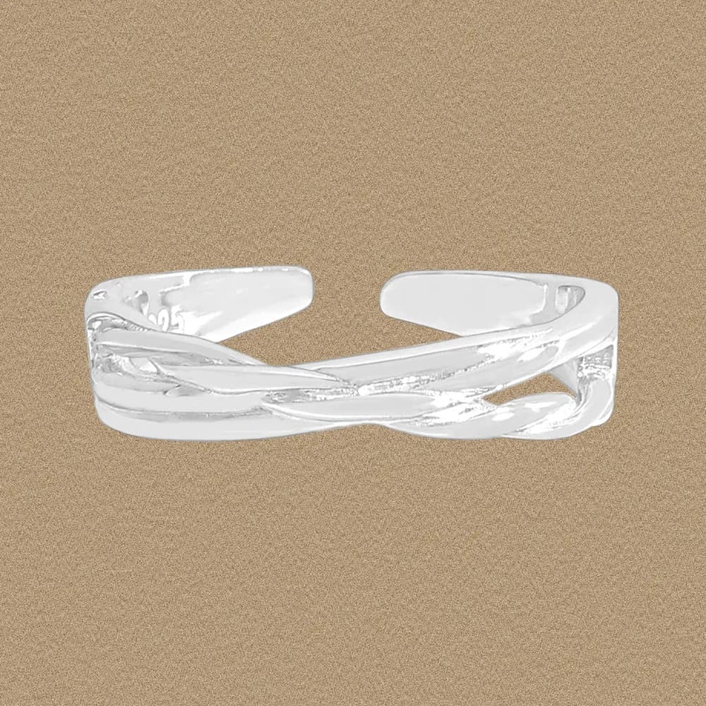 Open twisted silver band ring with overlapping ribbons on a beige background.