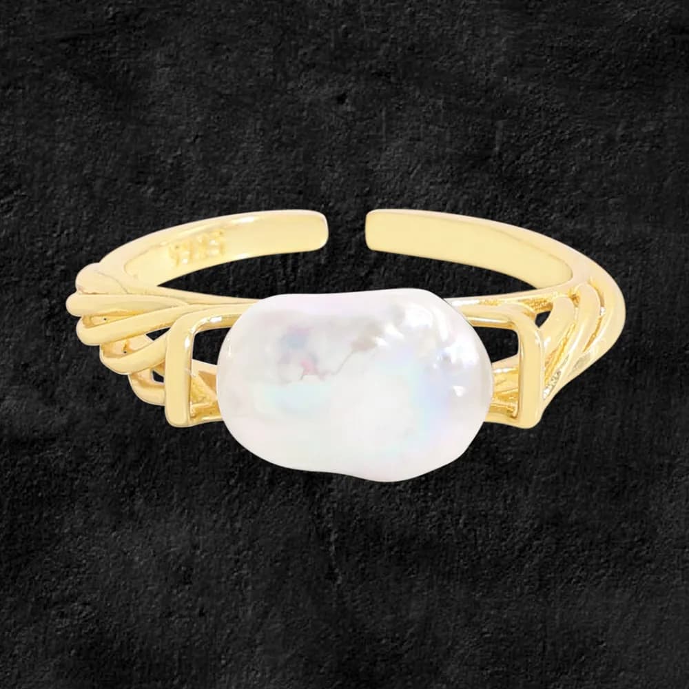 Close-up of a polished sterling silver ring with a large irregular pearl centerpiece in an open multi-band design.