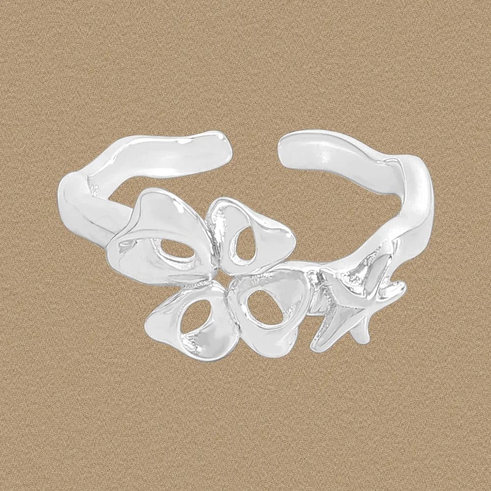 Polished sterling silver ring with interconnected petal shapes forming a cluster on a neutral background.