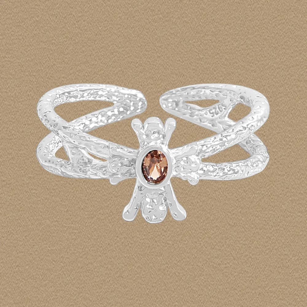 Sterling silver crisscross textured ring with a small peach gemstone at the center.