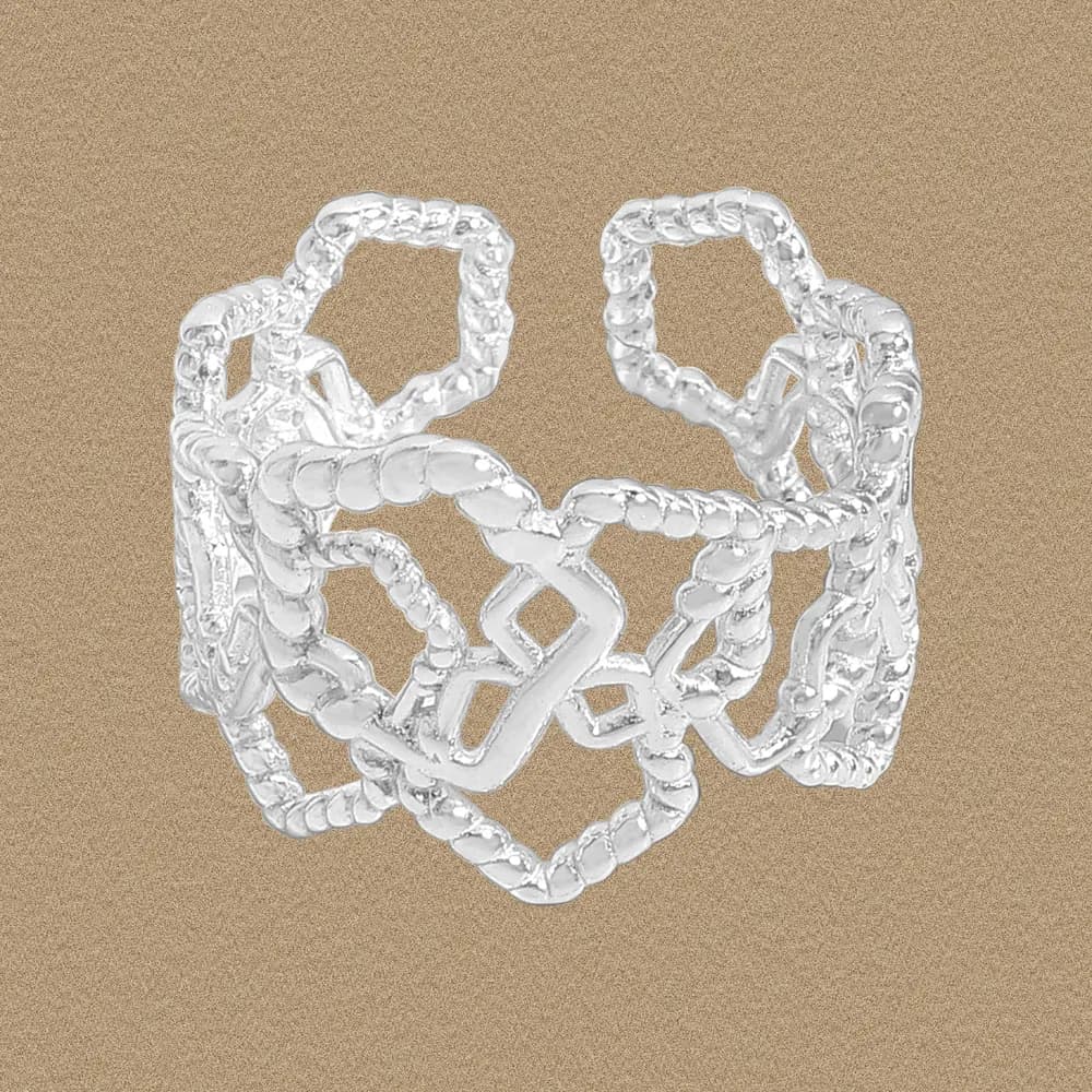 Wide sterling silver ring with interlocking geometric frames and rope-textured edges on a warm brown background