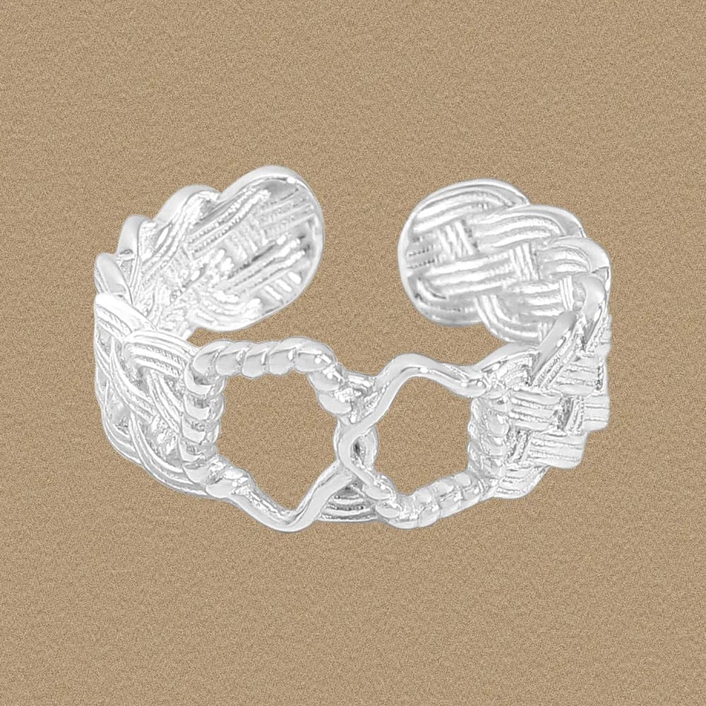 Polished sterling silver braided heart ring with open center on a neutral background