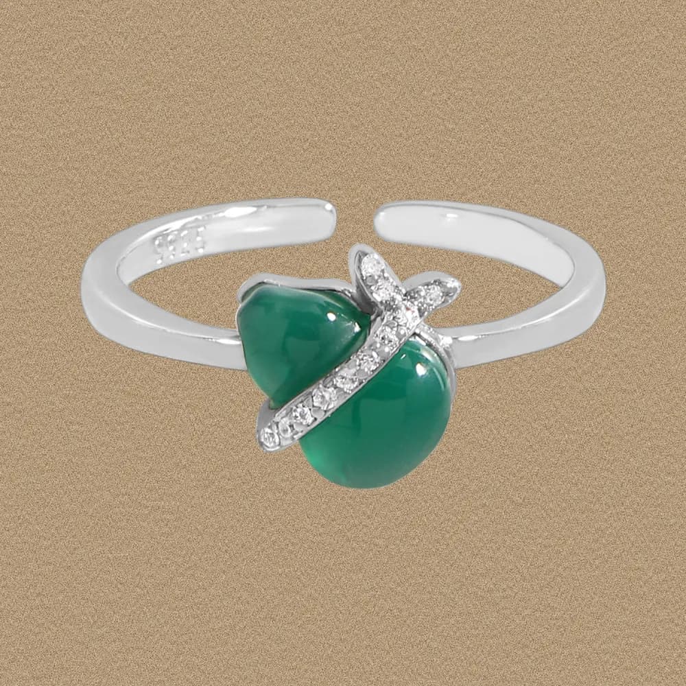 Sterling silver ring with a green double-lobed cabochon and crystal-wrapped accent on the band.