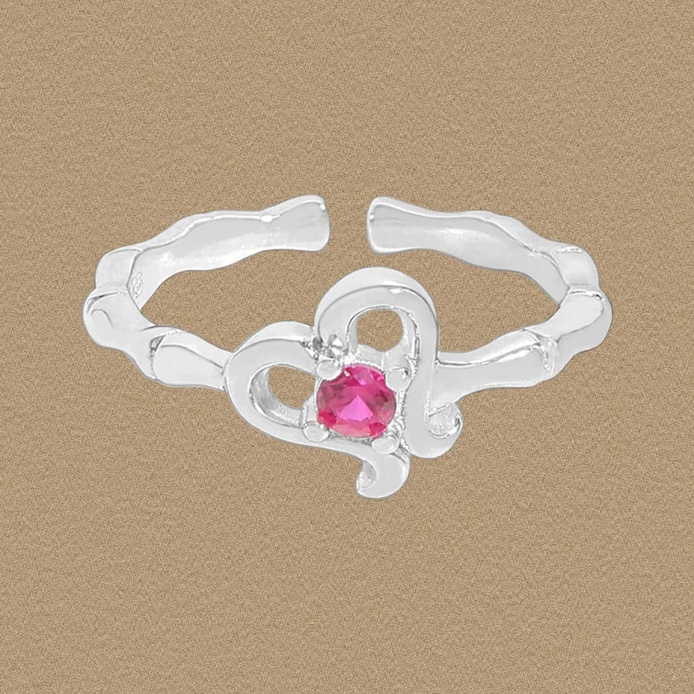 Polished sterling silver ring with a wavy band and pink gemstone centerpiece on a neutral background.