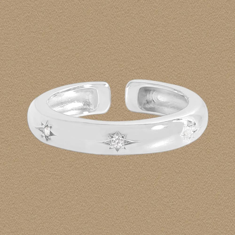 Polished sterling silver open-band cuff ring with small starburst motifs along the outer surface.